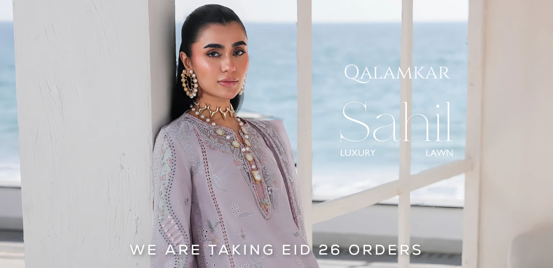 Woman in a lavender embroidered outfit with ocean view, Qalamkar Sahil brand text overlay.1621243260e1af0c20-2